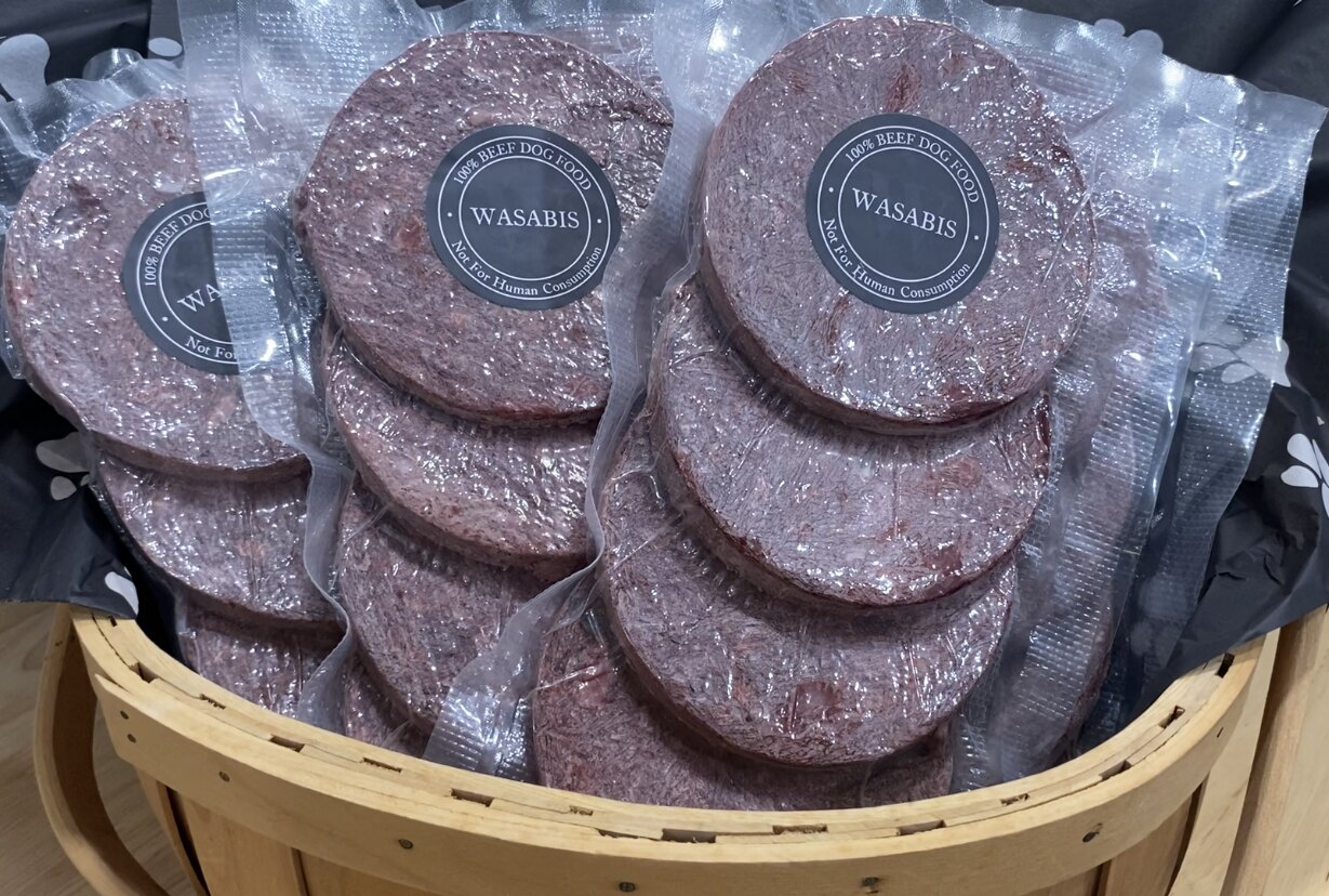 Individually packaged Wasabi’s beef dog food patties arranged in a product basket